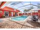 Inviting screened-in pool area with brick pavers, lounge chairs, and outdoor seating offers a relaxing retreat at 11296 Warm Wind Way, Weeki Wachee, FL 34613