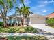 Charming single-Gathering home with well-manicured lawn, palm trees, and a two-car garage on a sunny day at 12327 Glenfield Ave, Tampa, FL 33626