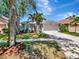 Beautiful home featuring a manicured front yard, palm trees, and a spacious two-car garage at 12327 Glenfield Ave, Tampa, FL 33626