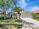 Charming home with a well-manicured front yard, lush landscaping, and an attached two-car garage at 12327 Glenfield Ave, Tampa, FL 33626