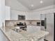 Bright kitchen featuring granite countertops, stainless steel appliances, and white cabinetry at 12327 Glenfield Ave, Tampa, FL 33626