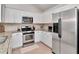 Well-lit kitchen with white cabinets, stainless steel appliances, and granite countertops at 12327 Glenfield Ave, Tampa, FL 33626