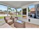 Enclosed lanai with wicker furniture and views of the backyard at 12327 Glenfield Ave, Tampa, FL 33626