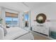 Bright bedroom featuring a bed, a large window with ocean views, and stylish decor elements, and access to the balcony at 1325 Snell Isle Ne Blvd # 911, St Petersburg, FL 33704