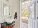 Bathroom with vanity and vessel sink, doorway leading to outdoor screened lanai at 13483 Heritage Way, Sarasota, FL 34240