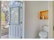 Powder room with toilet and decorative shelving leading to an outdoor screened lanai at 13483 Heritage Way, Sarasota, FL 34240