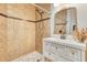 Bathroom features tiled walls and floor, white vanity with a decorative framed mirror, and a shower at 13483 Heritage Way, Sarasota, FL 34240