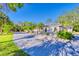 Long driveway curving in front of a one story home surrounded by palm trees at 13483 Heritage Way, Sarasota, FL 34240