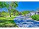 Extensive driveway with a pond and lush landscaping leading to a one story home at 13483 Heritage Way, Sarasota, FL 34240