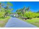 Long driveway leading to a beautiful one story home surrounded by mature landscaping at 13483 Heritage Way, Sarasota, FL 34240