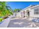 Elegant home exterior featuring a fountain, arched entryway, brick pavers, and lush landscaping with palm trees at 13483 Heritage Way, Sarasota, FL 34240