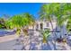 Stunning front exterior showcasing pristine landscaping with white stones, palm trees, and an arched entryway at 13483 Heritage Way, Sarasota, FL 34240