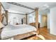 Bright main bedroom with four-poster bed, white walls, and arched windows at 13483 Heritage Way, Sarasota, FL 34240