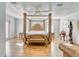 Spacious main bedroom showcasing a four-poster bed, hardwood floors, and natural light at 13483 Heritage Way, Sarasota, FL 34240