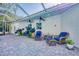 Covered patio with brick pavers features comfortable seating and lush landscaping at 13483 Heritage Way, Sarasota, FL 34240