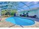 Inviting pool is surrounded by brick pavers and complemented by comfortable outdoor seating and lush landscaping at 13483 Heritage Way, Sarasota, FL 34240