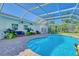 Inviting pool is surrounded by brick pavers and complemented by comfortable outdoor seating and lush landscaping at 13483 Heritage Way, Sarasota, FL 34240