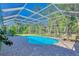 Backyard pool area features a screened enclosure, brick pavers, and a seating area at 13483 Heritage Way, Sarasota, FL 34240
