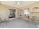 Covered back porch with two chairs, ceiling fan, and view of the interior at 1390 S Hillcrest Ave, Clearwater, FL 33756
