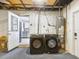 Unfinished basement area with washer and dryer and door to kitchen at 1390 S Hillcrest Ave, Clearwater, FL 33756