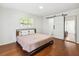 This bedroom has hardwood floors, a sliding barn door, and white shuttered windows at 1390 S Hillcrest Ave, Clearwater, FL 33756