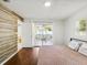 Bedroom with wood-look accent wall, sliding glass door to a screened patio, and a ceiling fan at 1390 S Hillcrest Ave, Clearwater, FL 33756