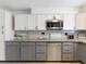 Updated kitchen featuring two-tone cabinets, modern appliances, and granite countertops at 1390 S Hillcrest Ave, Clearwater, FL 33756