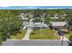 Aerial view of a single-story home with a manicured lawn, mature trees, and a paved driveway on a sunny day at 1410 Lime St, Clearwater, FL 33756