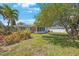 This home's backyard has a lush green lawn, beautiful trees, and plenty of room to relax and unwind outdoors at 1410 Lime St, Clearwater, FL 33756