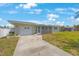 Charming one-story home featuring a convenient one-car garage, screened porch, and well-manicured lawn under a sunny sky at 1410 Lime St, Clearwater, FL 33756