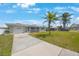 Charming single-story home featuring a one-car garage, screened porch, and well-maintained lawn under a bright blue sky at 1410 Lime St, Clearwater, FL 33756