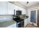 Kitchen featuring white cabinetry, stainless appliances, and exterior door access at 1410 Lime St, Clearwater, FL 33756