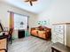 Bright bedroom with a ceiling fan, wood-look floors, and a charming daybed at 1803 Pacific Dunes Dr, Sun City Center, FL 33573