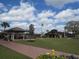 Wide view of community buildings, parking and green space, featuring a putting green and common areas at 1803 Pacific Dunes Dr, Sun City Center, FL 33573