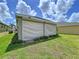 Backyard featuring the side of the house with a covered lanai and well-maintained landscaping at 1803 Pacific Dunes Dr, Sun City Center, FL 33573