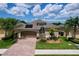 Charming single-story home featuring a brick driveway, two-car garage, and well-maintained landscaping at 1803 Pacific Dunes Dr, Sun City Center, FL 33573