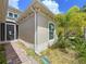 The exterior features a window and side entrance, complemented by colorful landscaping at 1803 Pacific Dunes Dr, Sun City Center, FL 33573