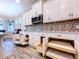 Kitchen features white cabinets with pull-out drawers for easy storage, mosaic backsplash, and wood floors at 1803 Pacific Dunes Dr, Sun City Center, FL 33573