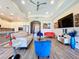 Bright living room with tile floors, tray ceilings, modern furniture, and an open layout to the kitchen at 1803 Pacific Dunes Dr, Sun City Center, FL 33573