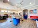 Bright, open-concept living room featuring modern furnishings, an open kitchen, and stylish wood-look tile flooring at 1803 Pacific Dunes Dr, Sun City Center, FL 33573