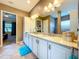 Bathroom featuring double sinks, white cabinetry and decorative lighting at 1803 Pacific Dunes Dr, Sun City Center, FL 33573