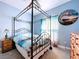 Light-filled bedroom with a four-poster bed, wood floors, and ocean themed decor at 1803 Pacific Dunes Dr, Sun City Center, FL 33573