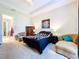 Spacious main bedroom with neutral carpet, tray ceilings, and ensuite bathroom access at 1803 Pacific Dunes Dr, Sun City Center, FL 33573