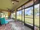 Spacious lanai featuring ceiling fans, outdoor seating, brick flooring, and large screened windows at 1803 Pacific Dunes Dr, Sun City Center, FL 33573