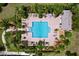 Aerial view of a community pool with lounge chairs, tables, and lush landscaping at 1803 Pacific Dunes Dr, Sun City Center, FL 33573