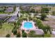 An aerial view shows a community pool, sun loungers and lush landscaping at 1803 Pacific Dunes Dr, Sun City Center, FL 33573