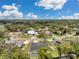 Stunning aerial view showcases home with screened pool nestled among lush trees in a serene residential neighborhood at 186 Dan River Dr, Spring Hill, FL 34606