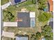 Aerial view of home showcasing a screened-in pool, mature trees, long driveway and well-kept landscaping at 186 Dan River Dr, Spring Hill, FL 34606