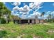 View of the backyard area that has an attached screened in pool, chimney, and updated patio at 186 Dan River Dr, Spring Hill, FL 34606