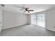 Bedroom showcasing neutral carpet, ceiling fan, and sliding glass doors at 186 Dan River Dr, Spring Hill, FL 34606